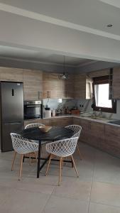a kitchen with a table and chairs and a refrigerator at Capital Apartment kilkis in Kilkis +5 photos
