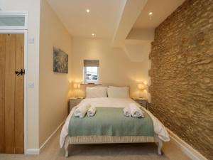 a bedroom with a bed with towels on it at Stanbridge Cottage in Malmesbury