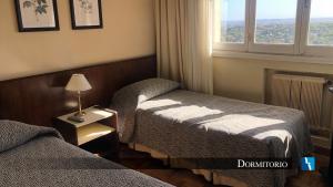 a hotel room with two beds and a window at Torres de Manantiales Apart Hotel in Mar del Plata +15 photos
