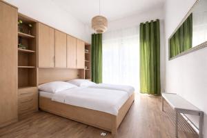 a bedroom with a large bed and green curtains at DUENENROSE App Nr 03 max 3 Pers in Dierhagen