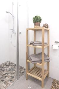 a bathroom with a wooden shelf with towels at DUENENROSE App Nr 03 max 3 Pers in Dierhagen