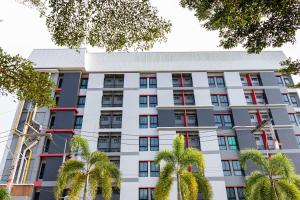 ein Wohnhaus mit Palmen davor in der Unterkunft Ps Sriphu Hotel in Hat Yai