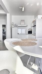 a white kitchen with white tables and white appliances at Terra & Salt in Bibinje