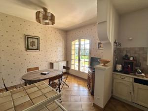 a kitchen with a table and a dining room at Villa Les Oliviers in Orange +22 photos