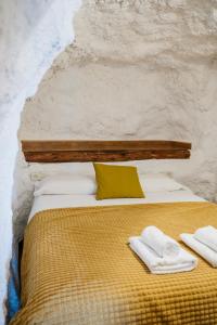 a bedroom with a bed with two towels on it at Cuevas El Atochal Orígenes in Gor