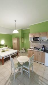 a kitchen with green walls and a table and chairs at House Eugenia Sarti in Sarti