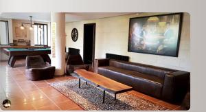 a living room with a couch and a pool table at Laklouk Village Vacances in Jbeil