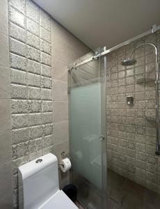a bathroom with a toilet and a glass shower at Laklouk Village Vacances in Jbeil