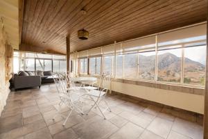 a dining room with a table and chairs in front of windows at Laklouk Village Vacances in Jbeil