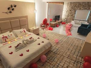 a bedroom with a bed with red hearts on it at روز بيلا 1 Rosa Bella in Al Jināh