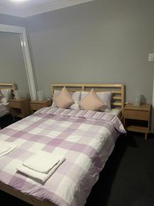 a purple and white bed with two towels on it at Coomera Private Rooms near DreamWorld in Gold Coast