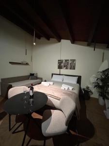 a bedroom with a bed and a table with a bottle of wine at Sarò rooms in Pietraperzia