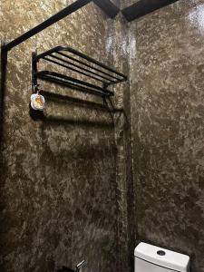a bathroom with a toilet and a rusty wall at Mojo Hostel in Puerto Princesa City +59 photos