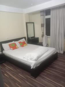 a bedroom with a bed with white sheets and pillows at De Hotel Veda Pvt Ltd in Thapathali