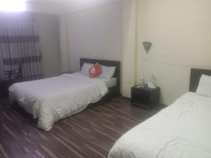 a bedroom with two beds and a table with a lamp at De Hotel Veda Pvt Ltd in Thapathali