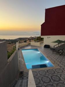 a large blue swimming pool sitting next to a building at Maison campagne piscine ksar in Ksar es Sghir