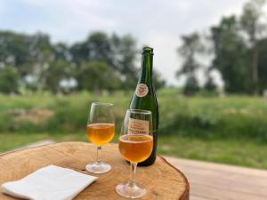a bottle of wine and two glasses on a table at Le Vert d'Orezza in Valliquerville +53 photos