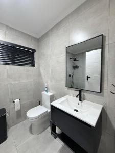 a bathroom with a sink and a toilet and a mirror at Executive Suite South Fork in Kimberley