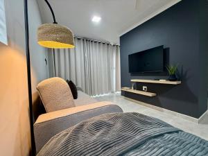 a bedroom with a bed and a tv and a chair at Executive Suite South Fork in Kimberley