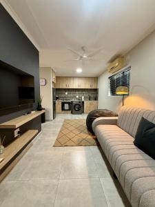 a living room with a couch and a tv at Executive Suite South Fork in Kimberley