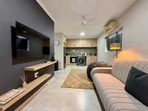 a living room with a couch and a flat screen tv at Executive Suite South Fork in Kimberley +19 photos