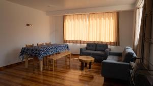 a living room with a table and a couch at Depa Urubamba in Urubamba