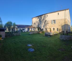 a large stone building with a yard in front of it at La hulotte de Labarthe in Mazères