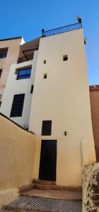 a white building with a black door at Esc 3 in Fez