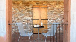 a table and two chairs on a balcony with a door at Villa Bella Vita in Biguglia