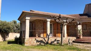 a small brick house with a tree in the yard at Villa Bella Vita in Biguglia