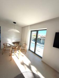 a dining room with a table and chairs and a window at Villa Čapula - Modern Apartment with Sea View and Parking, Marušići in Omiš
