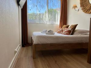 a bed in a room with a large window at Studio avec accès plage et mer in Dinard
