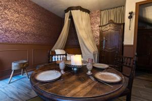 a room with a wooden table with a candle on it at Le Logis des Seigneurs in La Flocellière
