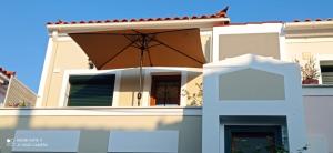 a house with an umbrella in front of it at Agapi's Nest in Petra