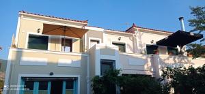 a white house with an umbrella on top of it at Agapi's Nest in Petra +13 photos