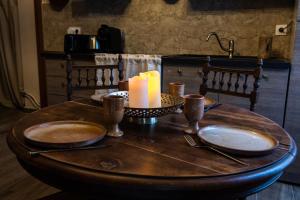 a wooden table with two plates and candles on it at Le Logis des Seigneurs in La Flocellière