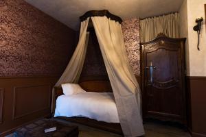 a bedroom with a bed with a canopy at Le Logis des Seigneurs in La Flocellière +8 photos