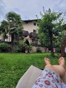a person laying on a book in the grass at Garni Guflhof in Caldaro