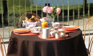 a table with a black table cloth and a table with food and flowers at MAISON des FORGES in Buffon +10 photos