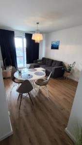 a living room with a couch and a table and chairs at Nowy w centrum 2 in Giżycko