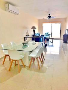 a dining room with a glass table and white chairs at Ph and apartments riviera Maya in Playa del Carmen