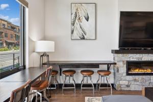 a dining room with a fireplace and a table and stools at Downtown Gem in Whitefish