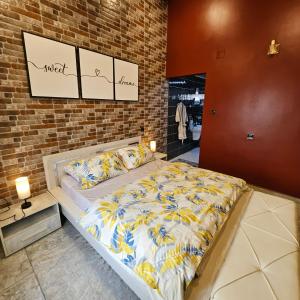 a bedroom with a bed and a brick wall at Penthouse in Le Hamiz