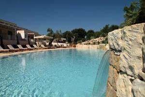 a large swimming pool in a resort with chairs at Borgo de li Santi in Otranto