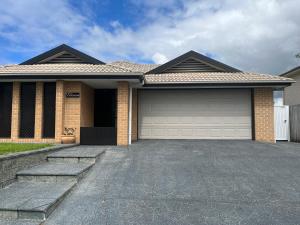 a brick house with a garage at Coomera Private Rooms near DreamWorld in Gold Coast