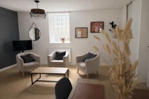 a living room with two chairs and a table at Flor du Mont Gîte in Pontorson