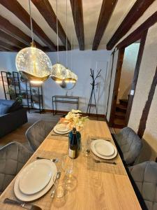 a dining room table with plates and wine glasses at Au Charme Amboisien - Centre-ville et climatisé in Amboise +12 photos