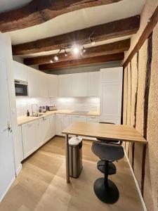 a kitchen with a wooden table and a chair at Au Charme Amboisien - Centre-ville et climatisé in Amboise