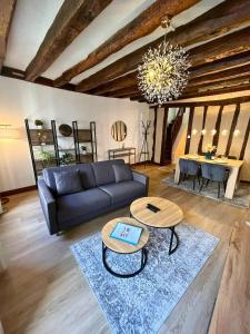 a living room with a couch and two tables at Au Charme Amboisien - Centre-ville et climatisé in Amboise