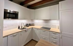a white kitchen with white cabinets and a sink at Au Charme Amboisien - Centre-ville et climatisé in Amboise